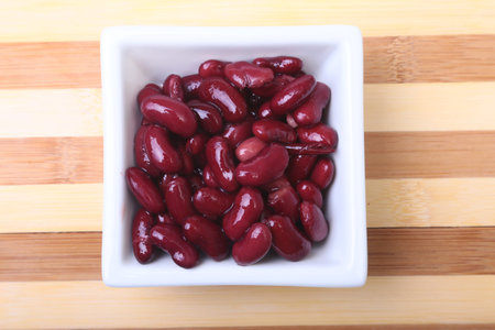 Heap of canned red kidney beans in the sauce in white bowl. vegetarian food. Phaseolus vulgaris.
