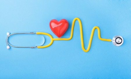 Red heart and a stethoscope on blue backgroundの写真素材
