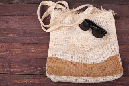 canvas beach bag and sunglasses on a wooden backgroundの写真素材