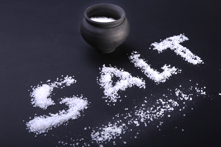 White sea salt isolated on a black background. Selective focus.の写真素材