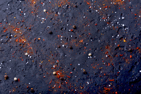Red spices, salt and pepper on black marble. Black abstract background. Top view.の写真素材