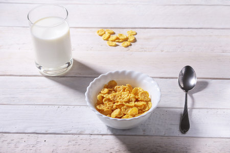 Corn Flakes cereal in a bowl and glass with milk. Morning breakfast.の写真素材