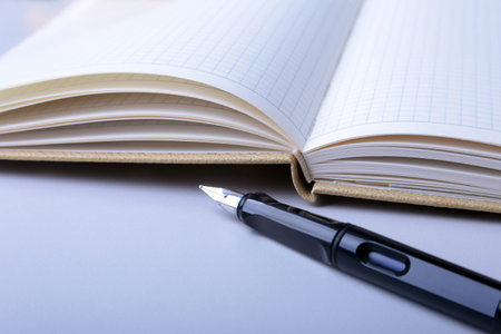 Business accessories on desktop: notebook, diary, fountain pen, glasses. Macro with blur and soft...