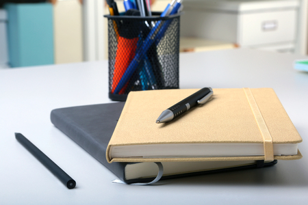 Business accessories on desktop: notebook, diary, fountain pen, glasses. Macro with blur and soft focusの写真素材