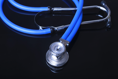 stethoscope, Red heart on black mirror background. Selective focus.の写真素材