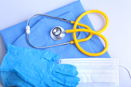 Medical stethoscope, gloves, RX prescription, and blue doctor uniform closeup. Medical help or insurance concept. Cardiology care, health, protection and prevention.の写真素材