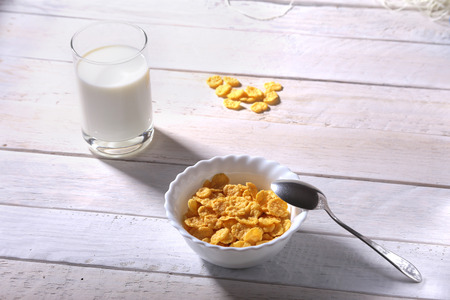 Corn Flakes cereal in a bowl and glass with milk. Morning breakfast.の写真素材