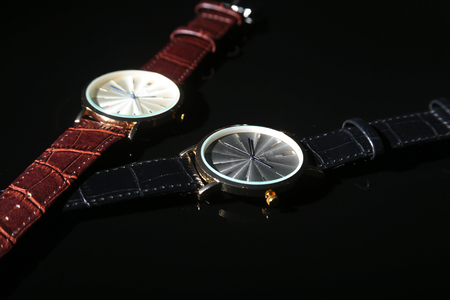 Men's accessories with brown leather wallet, belt and watch on black mirror background.の写真素材