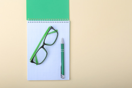 Business accessories on desktop: notebook, diary, fountain pen, glasses. Macro with blur and soft focus.の写真素材