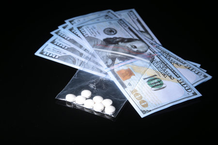 drug trafficking, crime, addiction and sale concept - closeup of with drugs and money.