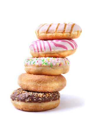 assorted delicious homemade doughnuts in the glaze, colorful sprinkles and nuts isolated on white background.の写真素材