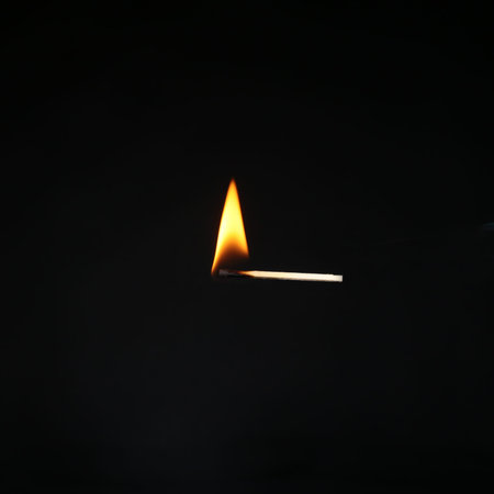 Burning match on a dark background . Cluse up