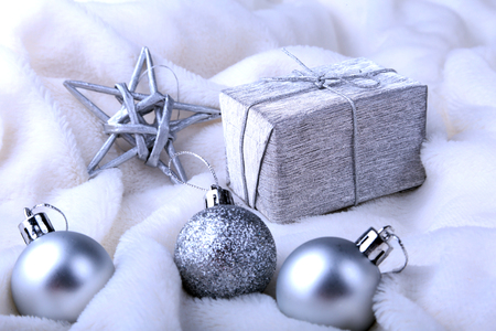 Silver gift box with ribbon bow and Christmas balls on white. Decoration for happy holidays.の写真素材