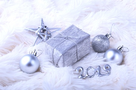 Silver gift box with ribbon bow and Christmas balls on white. Decoration for happy holidays.の写真素材