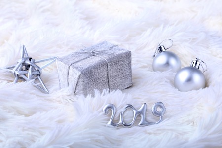 Silver gift box with ribbon bow and Christmas balls on white. Decoration for happy holidays.の写真素材