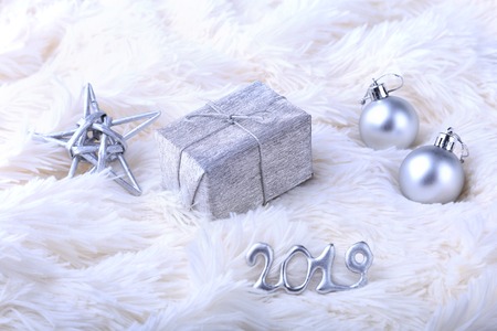 Silver gift box with ribbon bow and Christmas balls on white. Decoration for happy holidays.の写真素材