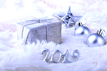 Silver gift box with ribbon bow and Christmas balls on white. Decoration for happy holidays.の写真素材