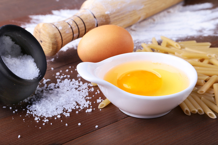egg, flour, salt ingredients for pasta penne bolognese. Cooking concept. Top view.の写真素材