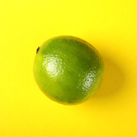 Fresh exotic lime on yellow background. Fruits background. Top view.の写真素材