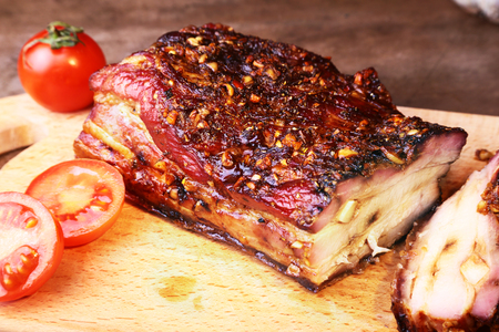 Sliced grilled pork ribs barbecue Striploin steak with chimichurri sauce and tomatoes on cutting board on dark background.の写真素材