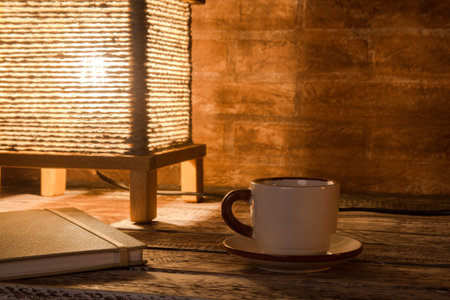 Cup of coffee, notebook and vintage table lamp.の写真素材