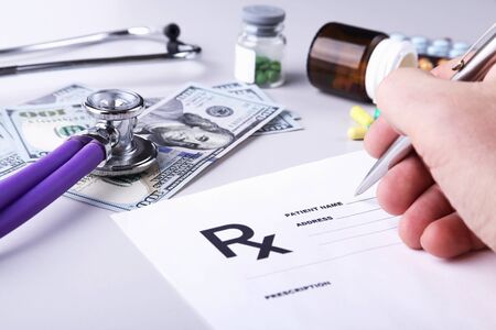 Male doctor or pharmacist holding jar or bottle of pills in handの写真素材