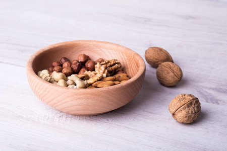 wood serving spoon with Assortment nuts on wooden table. Close-up.