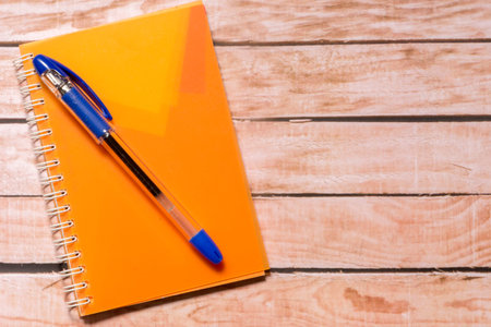 Notepad and pen on top of a wooden board