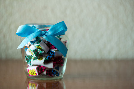 A glass jar with a bow full of candy