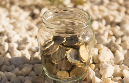 A transparent jar with many coins savedの写真素材