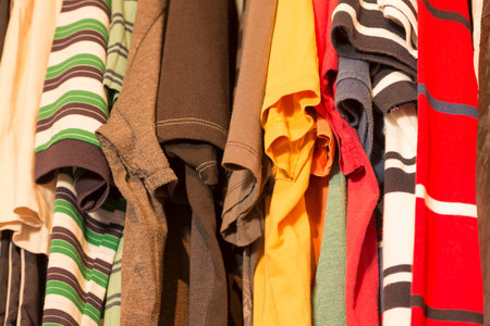 A man's closet with several t-shirts of various colorsの写真素材
