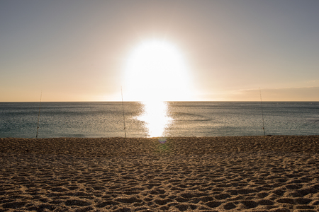 Fishing rods at sunrise on a beach, Almeriaの写真素材