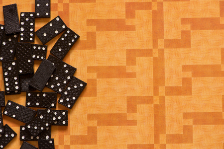 Small black dominoes on an orange backgroundの写真素材