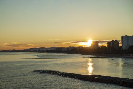 Sunset between the buildings on the coast of Benicassim, Costa Azahar, Spainの写真素材