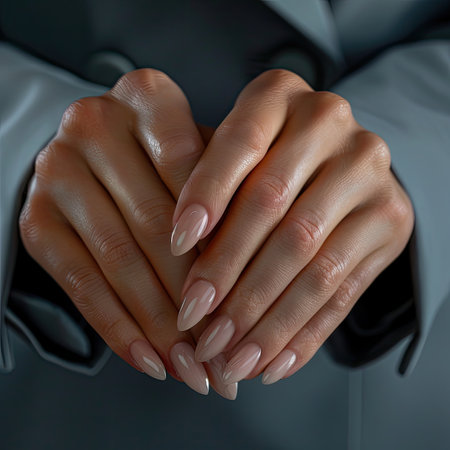 Female hands with long nails and a bottle of nail polish manicureの素材