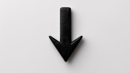 A black arrow is placed on a white surface. The arrow points straight down. The image shows a simple symbol used for indicating direction. It is clean and clear with no other objects.の素材
