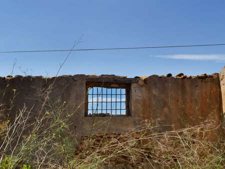 Section of a ruined house. No ceiling, one window with grating opend to the blue sky.の写真素材