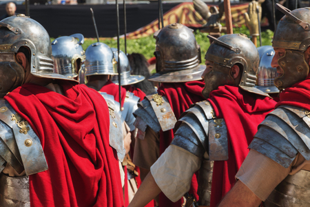 Rome/Italy/04/22/2018 Rome foundation anniversary.A group of soldiers at the historical parade in a sunny day at the Circo massimo.Detail of the helmets with the face mask.Red cloaks stand out in the photoのeditorial素材