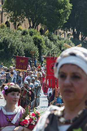 Rome/Italy/04/22/2018Historical parade.In the foregroung two female faces out of focus.In the background a military roman group march.Vertical compositionのeditorial素材