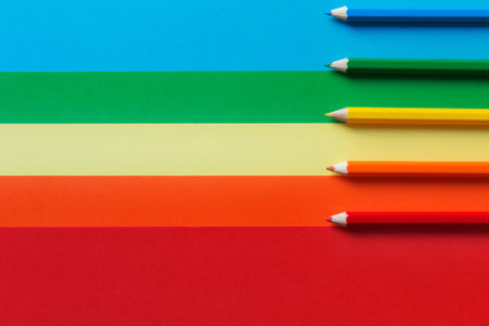 Five different colored pencils on a multicolored background.A horizontal and graphic composition,rainbow effectの写真素材