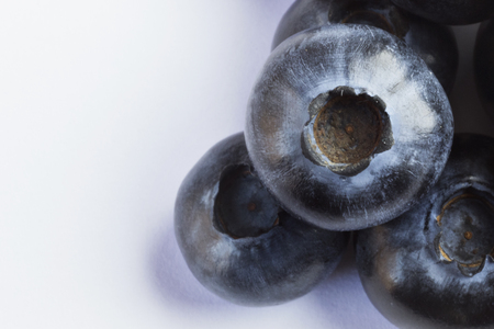 A pile of bilberries, macro photography, white background, studio shot, top view, soft shadowsの写真素材