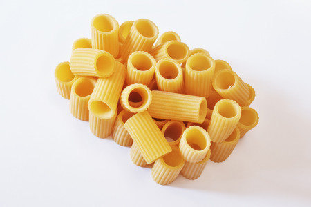 Italian pasta called mezzi rigatoni on a  white background ,tube-shaped pasta with ridges down their lenght , studio shot ,の写真素材