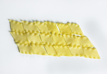 Dry Italian pasta called pantacce  on a white background,rhombus - shaped pasta with wavy edge.の写真素材