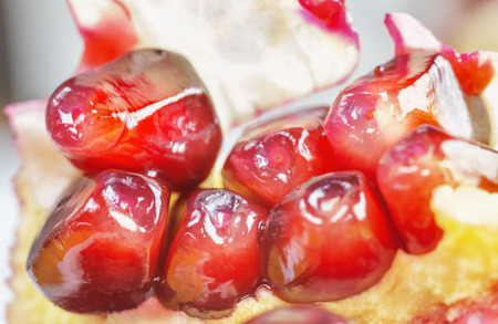 Bright red pomegranate seeds in closeup shotの写真素材