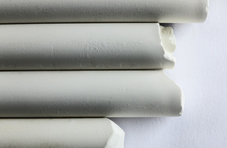 Four different pieces of chalk on a white background , horizontal composition , high contrast , abstract effectの写真素材