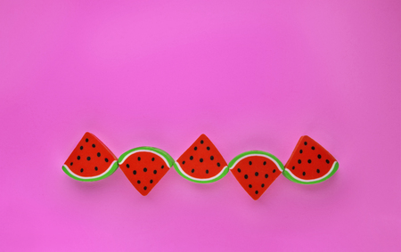 A group of erasers shaped like sliced watermelon in a row on a colored background ,simple compositionの写真素材