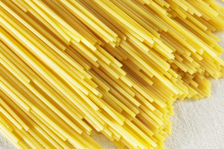 Dried pasta spaghetti , long and thin solid cylindrical pasta in diagonal lines , abstract effect ,の写真素材