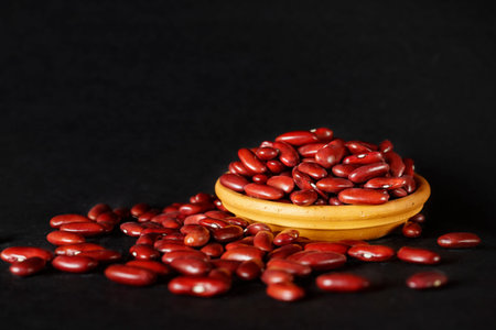 Common red beans -kidney bean - on black background , part of the beans are in a bowlの写真素材