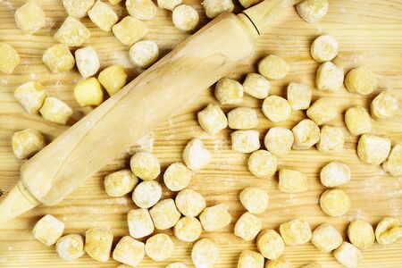 Raw gnocchi on  wooden board   , uncooked food with flour with a rolling pinの写真素材