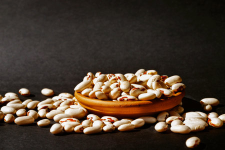 Heap of Scicli beans -Sicily -on dark background ,creamy white cannellini -type beans with reddish...